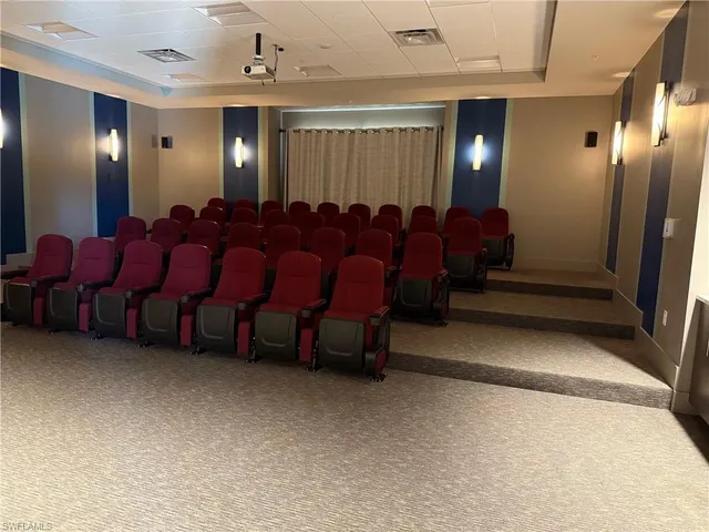 a media room with lots of chairs and chandelier