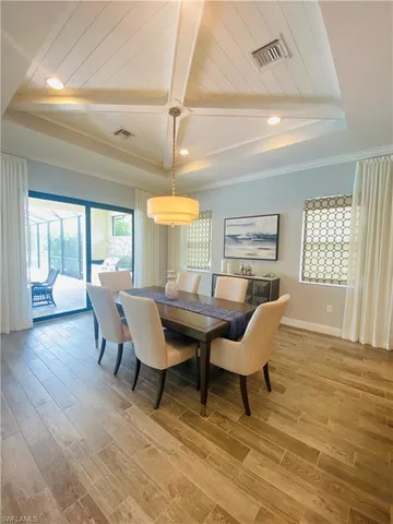 a dining room with furniture a chandelier and wooden floor