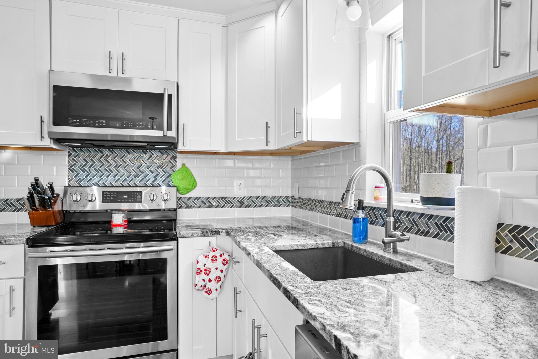 1435 Shadyrest Road Shady Side, MD 20764 - Photo 11 of 36 a kitchen with granite countertop a stove top oven a sink a counter space and cabinets