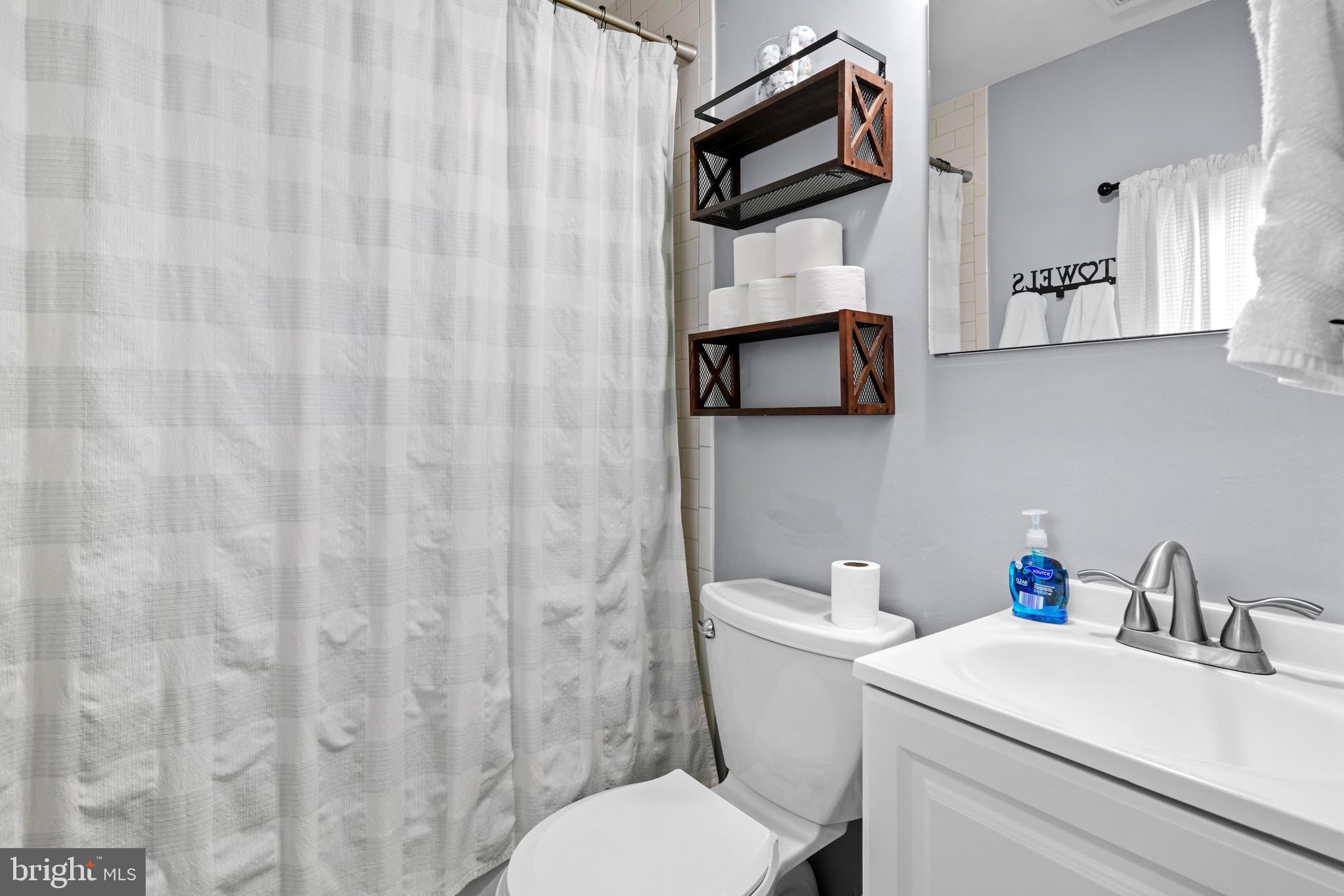 1435 Shadyrest Road Shady Side, MD 20764 - Photo 17 of 36 a white toilet sitting next to a white sink and curtain