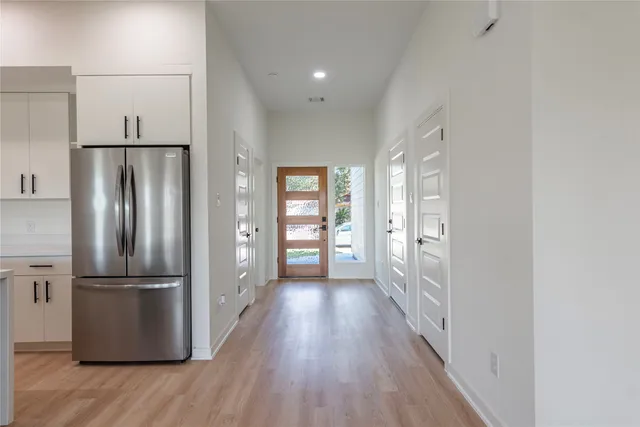 a kitchen with stainless steel appliances a refrigerator and wooden floor