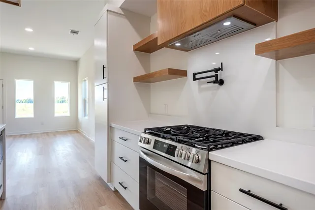 a kitchen with stove and cabinets