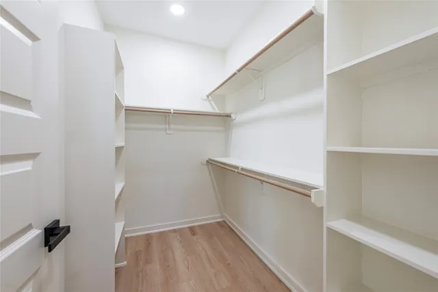 a view of walk in closet with empty racks