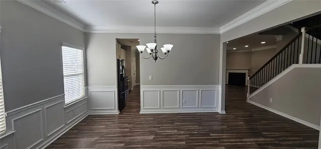 a view of a livingroom with wooden floor and staircase