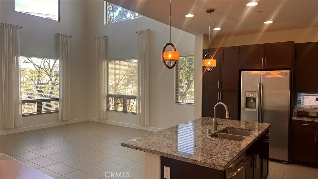 27 Soho Irvine, CA 92612 - Photo 5 of 69 a kitchen with kitchen island granite countertop a sink and a refrigerator
