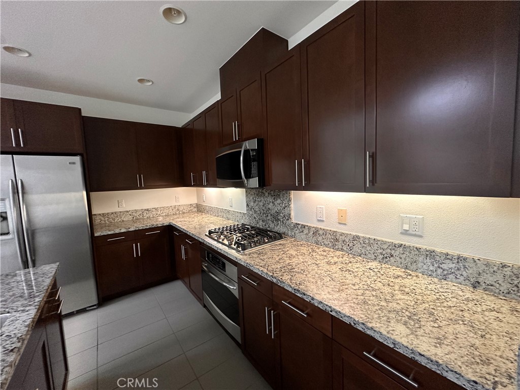 27 Soho Irvine, CA 92612 - Photo 10 of 69 a kitchen with granite countertop stainless steel appliances and wooden cabinets