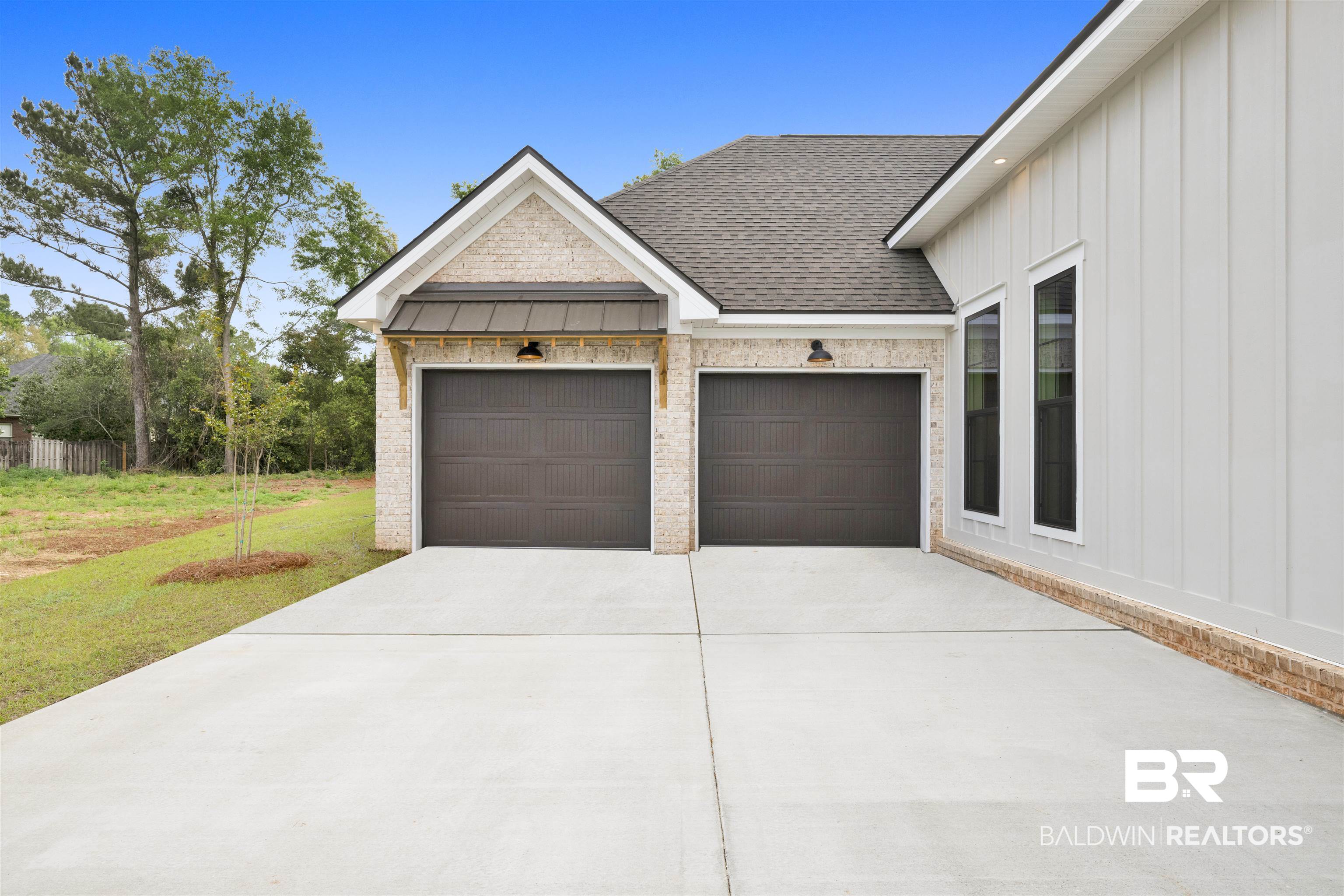 27382 Patch Pl Loop Daphne, AL 36526 - Photo 4 of 31 View of front of house featuring a standing seam roof, board and batten siding, a garage, and concrete driveway