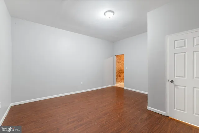 an empty room with wooden floor and window
