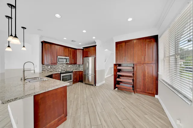 a view of a kitchen with wooden floor and a window
