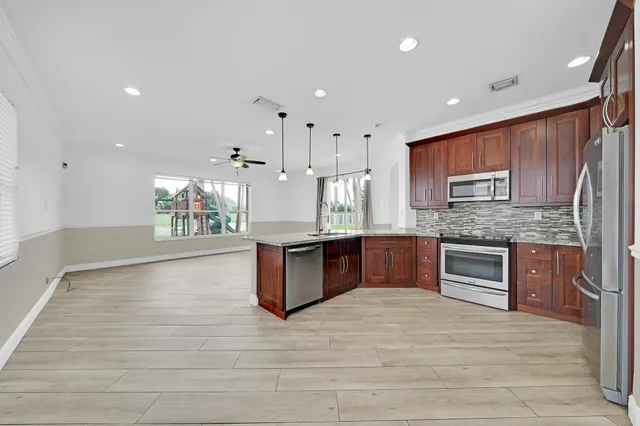 a kitchen with stainless steel appliances granite countertop a sink a stove and a refrigerator