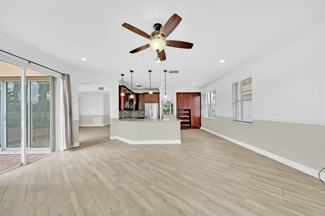 a view of a house with a yard and coconut trees