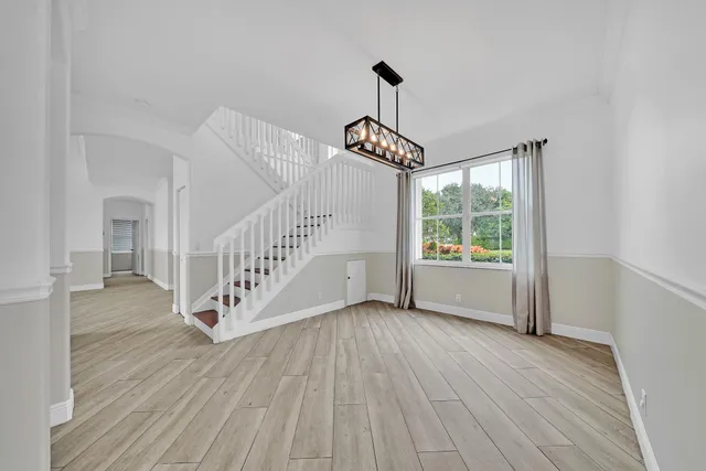 a view of a house with a yard and palm trees