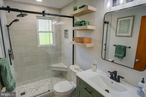 a bathroom with a sink a toilet and shower