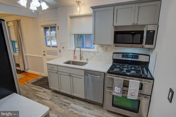 a kitchen with stainless steel appliances a stove a microwave and a sink
