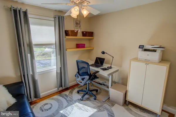 a view of a workspace with furniture and a window