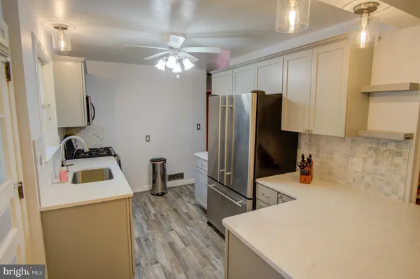 a kitchen with a refrigerator a sink and wooden floor