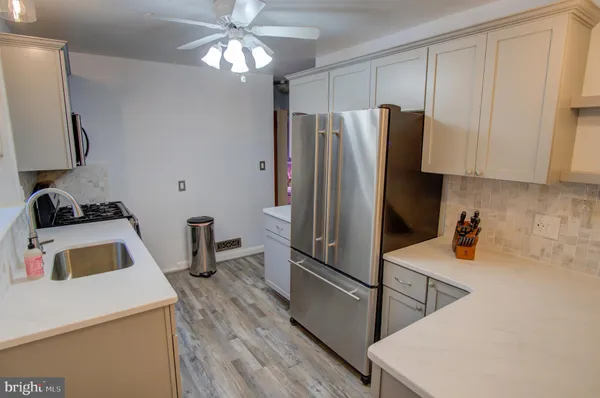 a kitchen with a refrigerator sink and cabinets