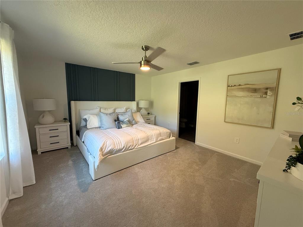 4220 Southwest 82nd Lane Ocala, FL 34476 - Photo 6 of 18 a bedroom with a bed and a chandelier