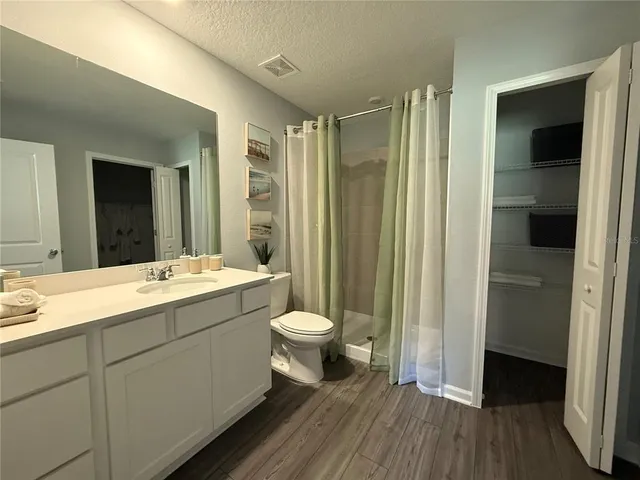 a bathroom with a double vanity sink toilet and shower