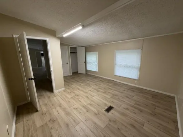 an empty room with wooden floor and a window