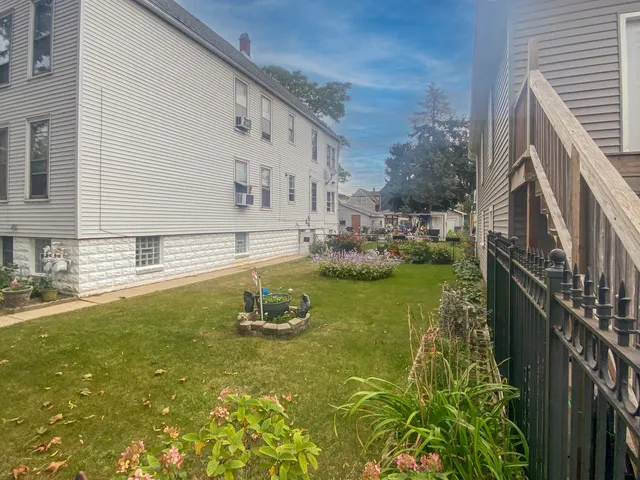 a view of a house with backyard and sitting area