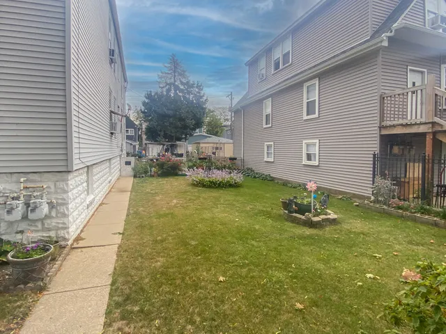 a backyard of a house with table and chairs