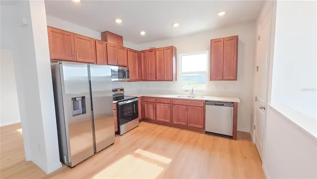 a kitchen with stainless steel appliances granite countertop a refrigerator sink and cabinets