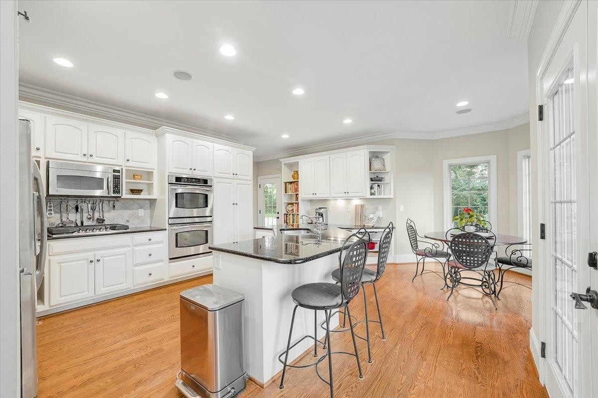5401 Nicks Road Mebane, NC 27302 - Photo 11 of 53 an open kitchen with white cabinets and stainless steel appliances