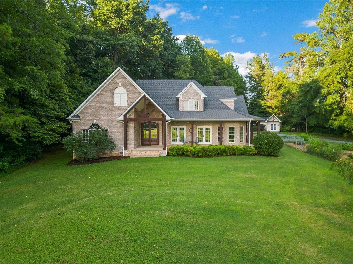 5401 Nicks Road Mebane, NC 27302 - Photo 3 of 53 a view of a brick house with a big yard and large trees