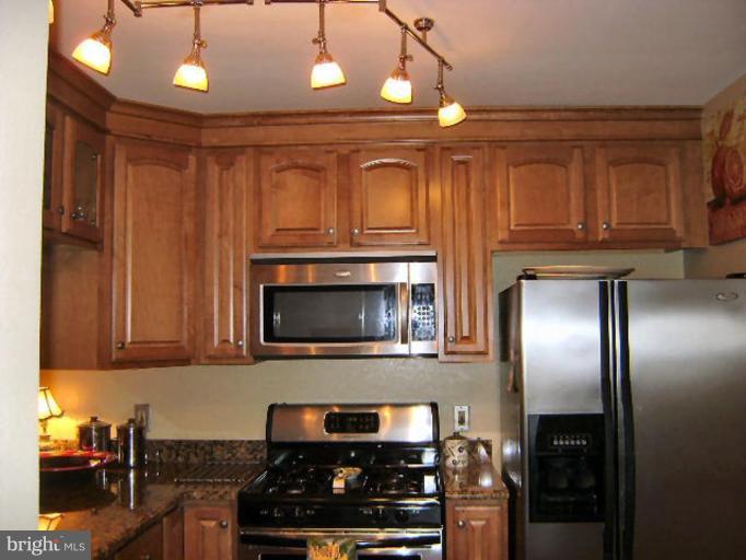 604 Churchill Road, Unit O Bel Air, MD 21014 - Photo 11 of 30 a kitchen with granite countertop stainless steel appliances and wooden cabinets