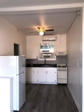a kitchen with granite countertop a stove a sink dishwasher and a refrigerator