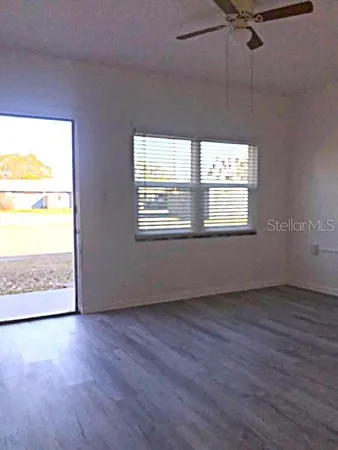 a view of a big room with wooden floor and windows