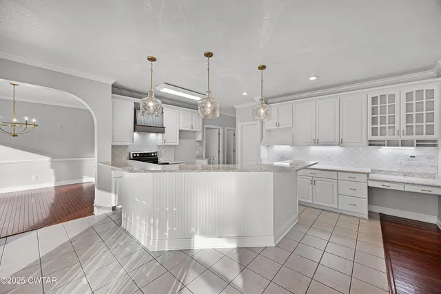 a kitchen with cabinets and chairs