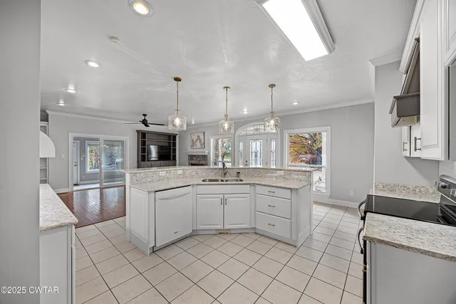 a kitchen with white cabinets a sink dishwasher and a stove with wooden floor