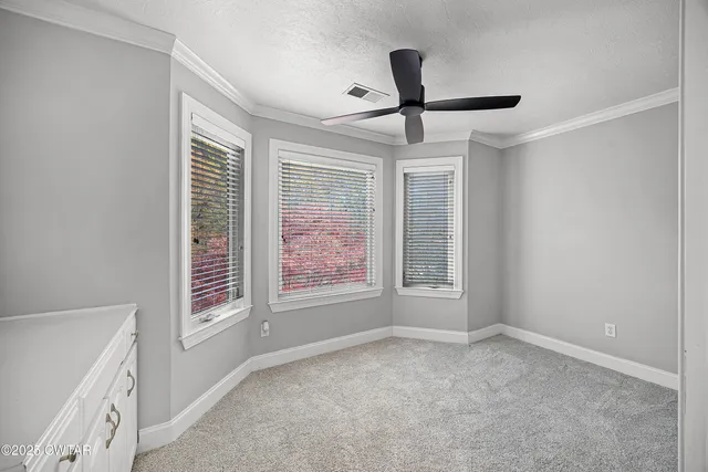 a view of a room with a ceiling fan and window