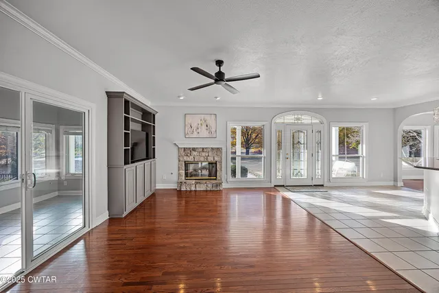 a view of an empty room with window and wooden floor