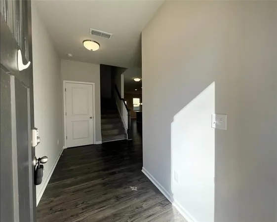 a view of a hallway with wooden floor and staircase