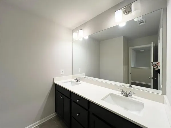 a bathroom with a double vanity sink and a mirror
