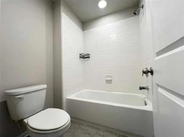 a white toilet and tub sitting next to a bathroom sink