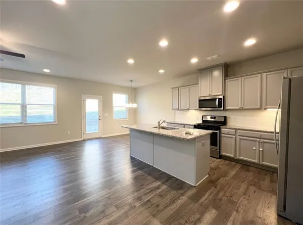 a kitchen with granite countertop a stove top oven sink and cabinets