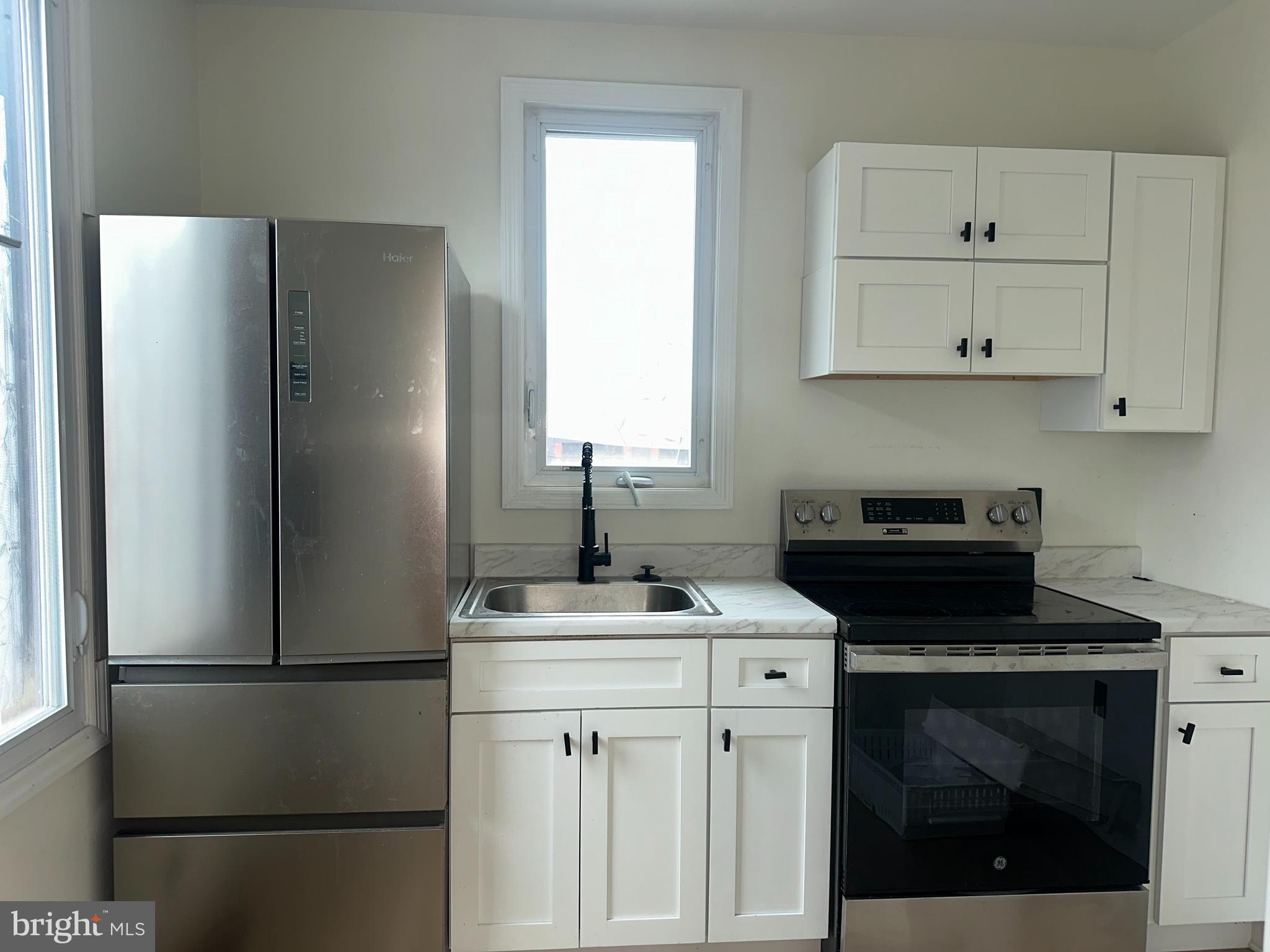 2000 Palethorp Street Philadelphia, PA 19122 - Photo 23 of 38 a kitchen with a refrigerator sink and cabinets