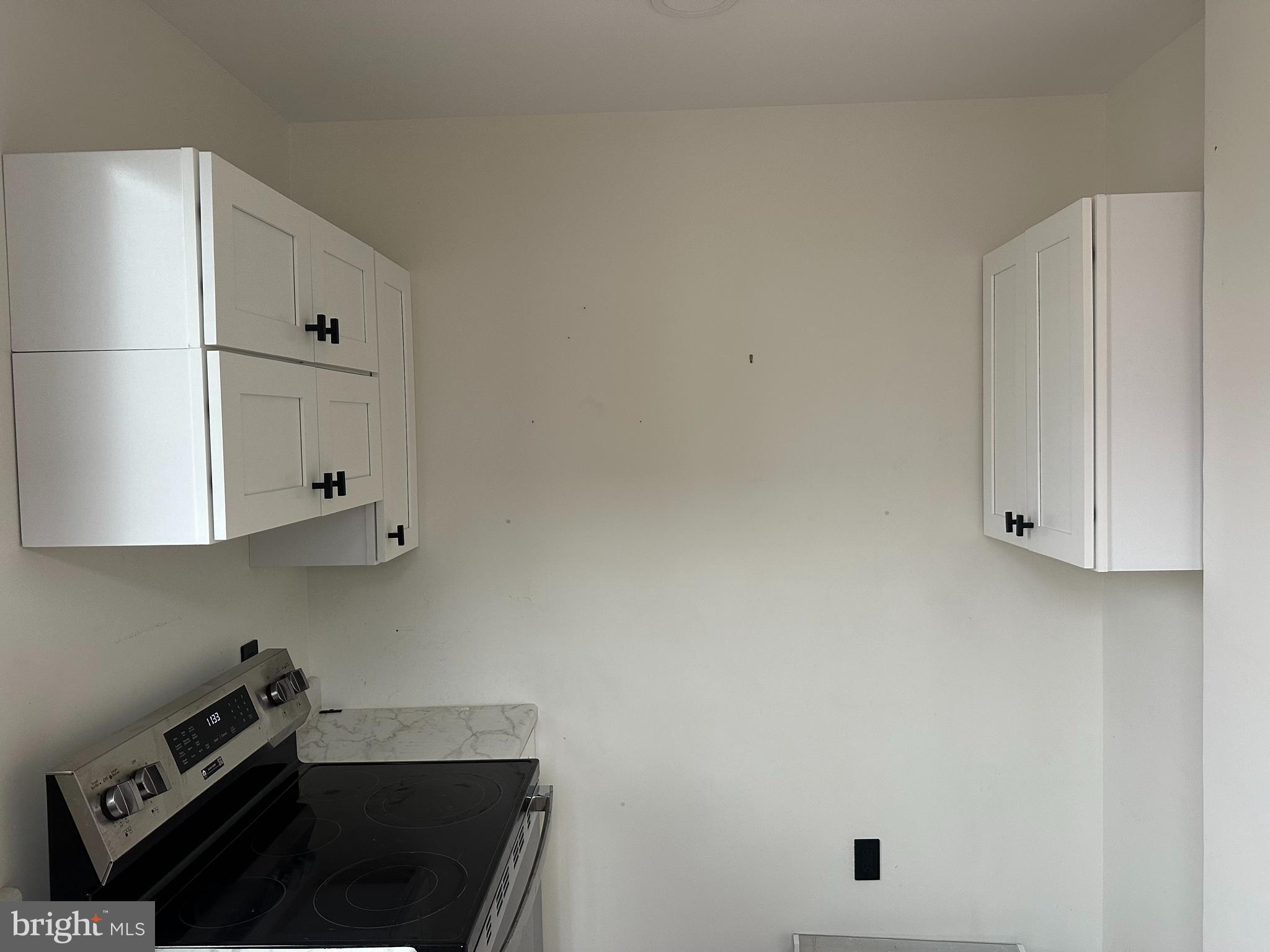 2000 Palethorp Street Philadelphia, PA 19122 - Photo 25 of 38 a kitchen with white cabinets and black appliances