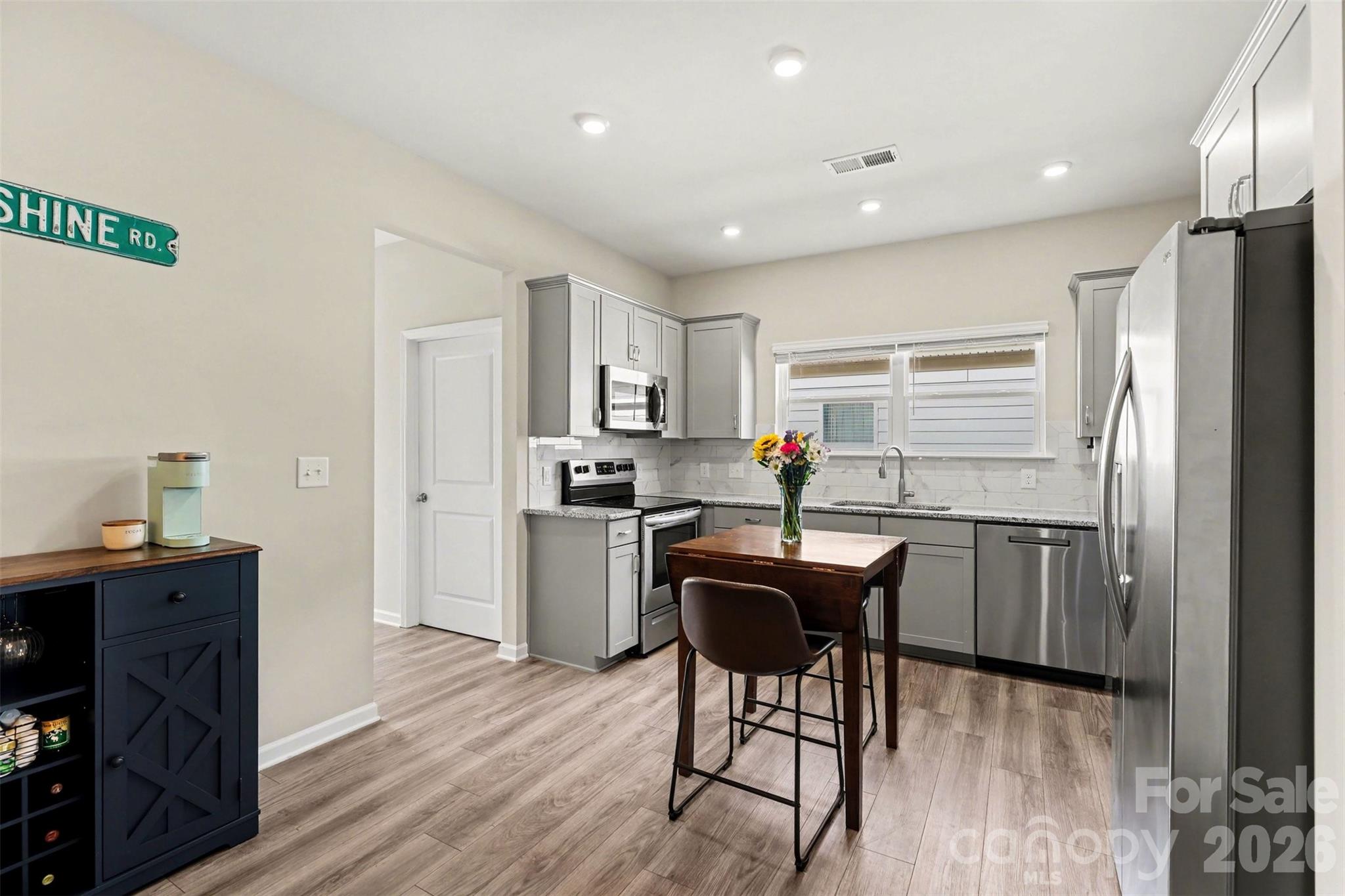 248 Kerri Dawn Lane Locust, NC 28097 - Photo 11 of 25 a kitchen with stainless steel appliances granite countertop a refrigerator a sink dishwasher a stove with wooden cabinets and wooden floor