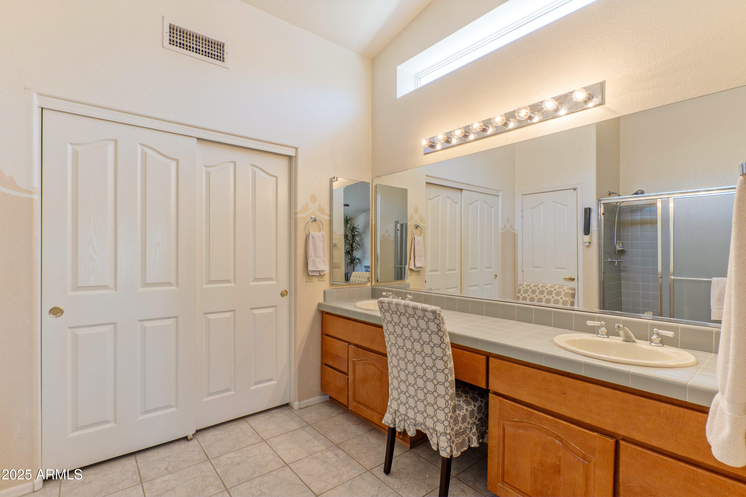 15371 Piccadilly Road Goodyear, AZ 85395 - Photo 14 of 26 a bathroom with a granite countertop sink a mirror and a shower