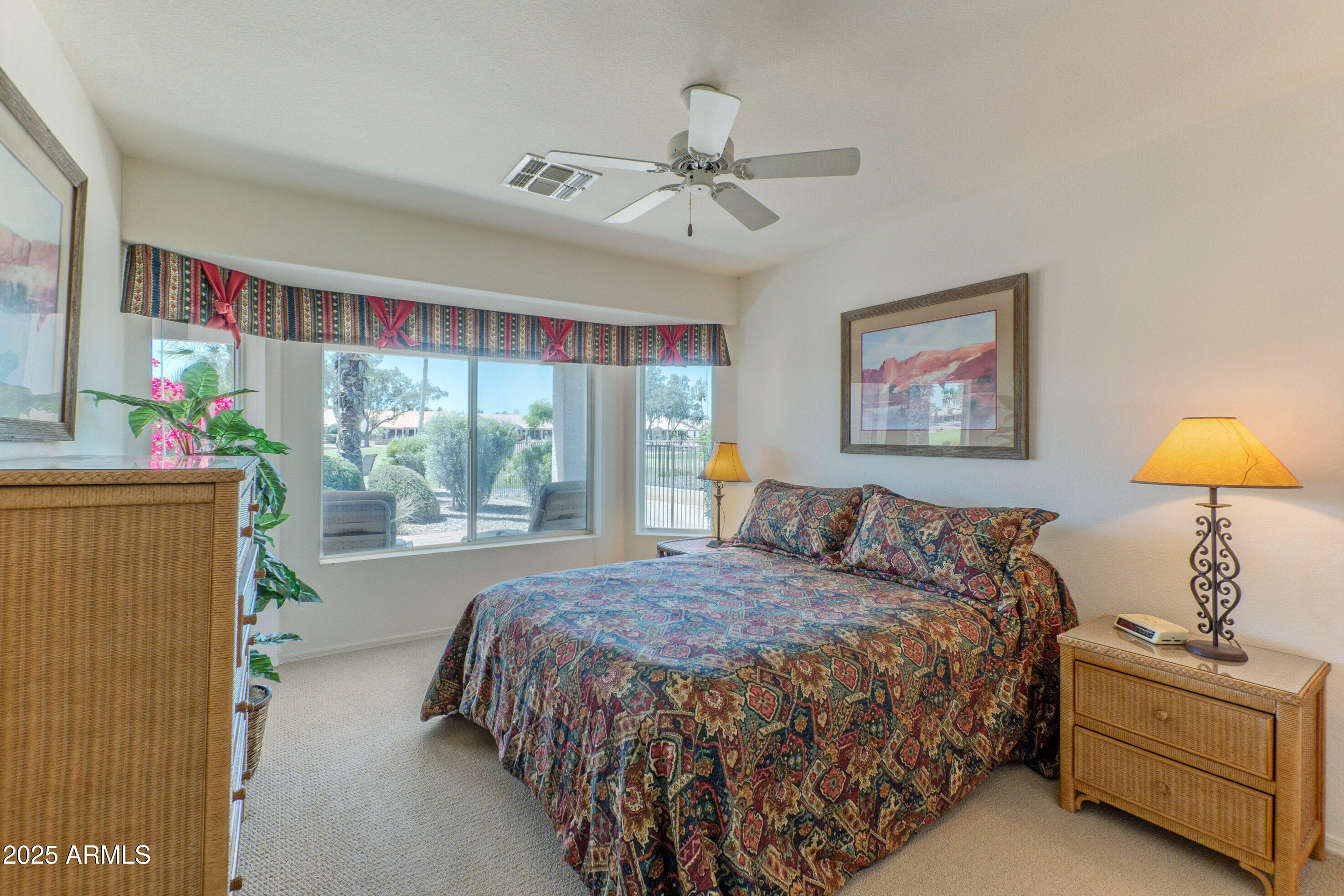 15371 Piccadilly Road Goodyear, AZ 85395 - Photo 15 of 26 a bedroom with a bed and a chandelier