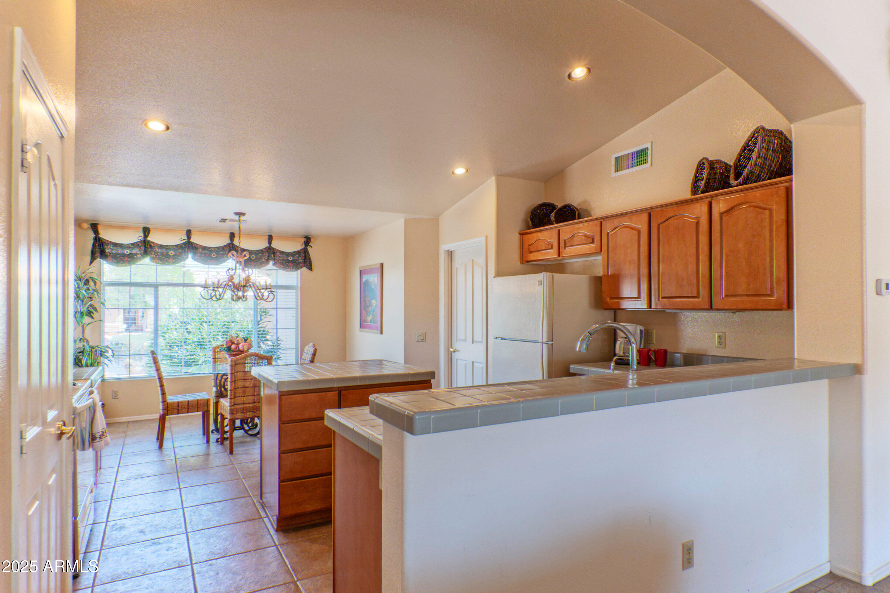 15371 Piccadilly Road Goodyear, AZ 85395 - Photo 8 of 26 a large kitchen with a large counter top furniture and a view of living room