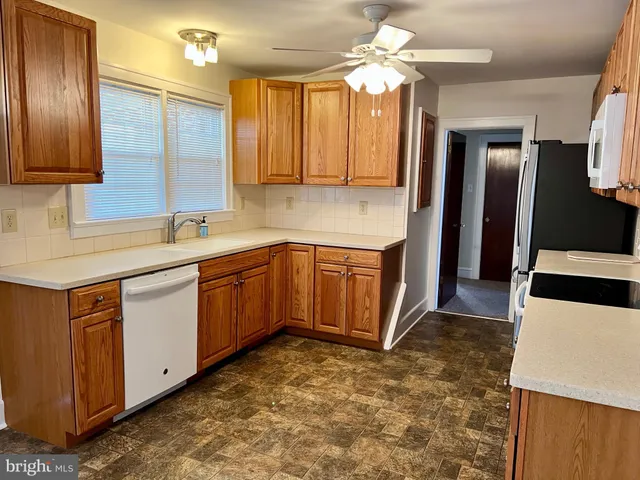 a kitchen with a sink refrigerator and cabinets