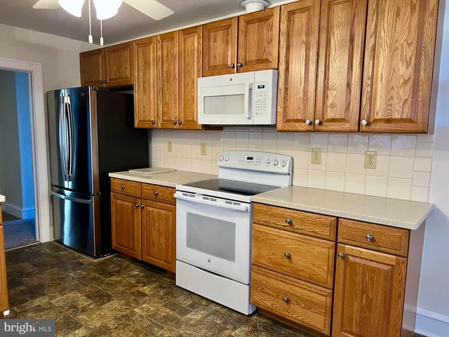 a kitchen with stainless steel appliances granite countertop a refrigerator stove and sink with dishwasher