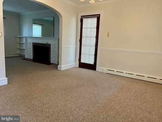 an empty room with windows fire place and fireplace