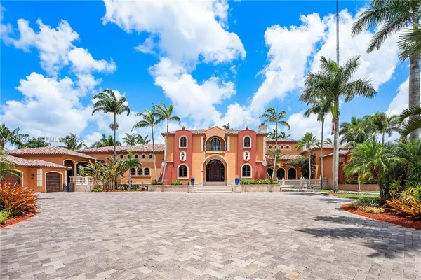 a front view of multi story residential apartment building with yard and retail shops